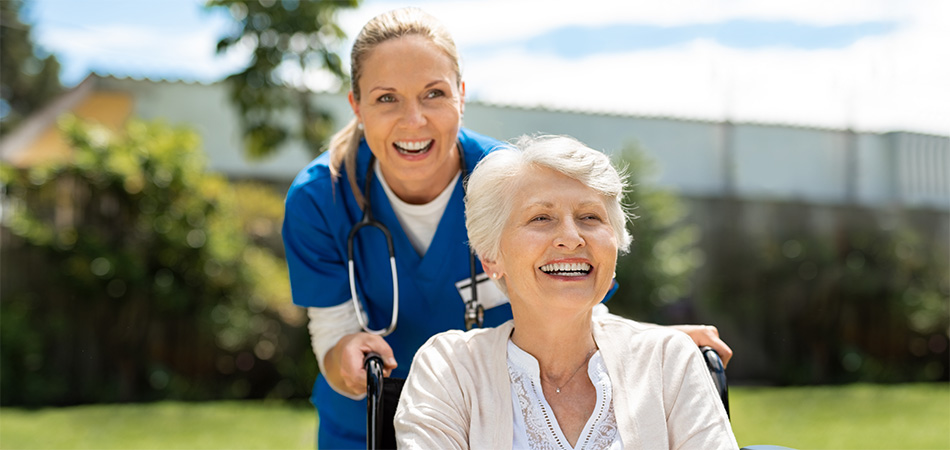 A nurse taking a patient out for a stroll.